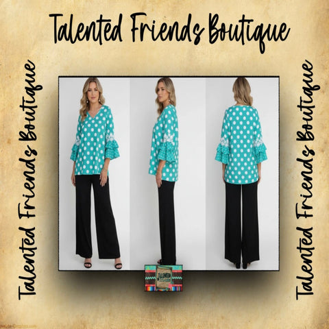 Woman wearing a teal polka dot top and black pants with 'Talented Friends Boutique' branding.